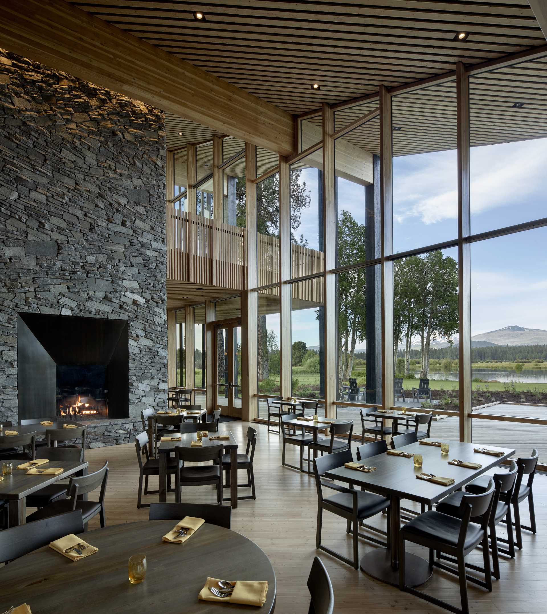 A modern ranch lodge with a black charred cedar exterior (shou sugi ban) and a warm wood interior.