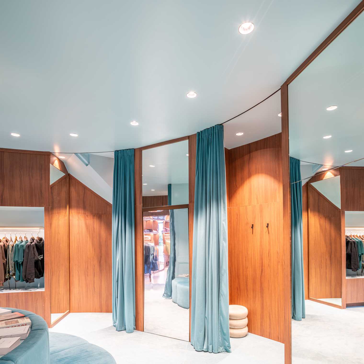 A modern streetwear retail store with 19-foot-high wooden bookshelves, a DJ booth, and a fitting room with baby blue accents.