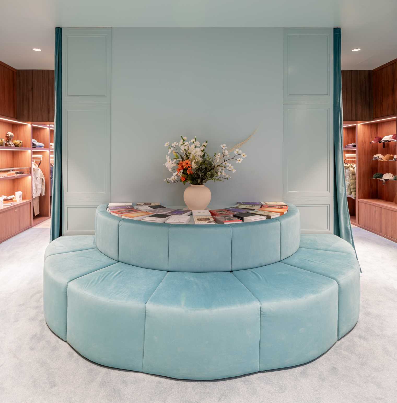 A modern streetwear retail store with 19-foot-high wooden bookshelves, a DJ booth, and a fitting room with baby blue accents.