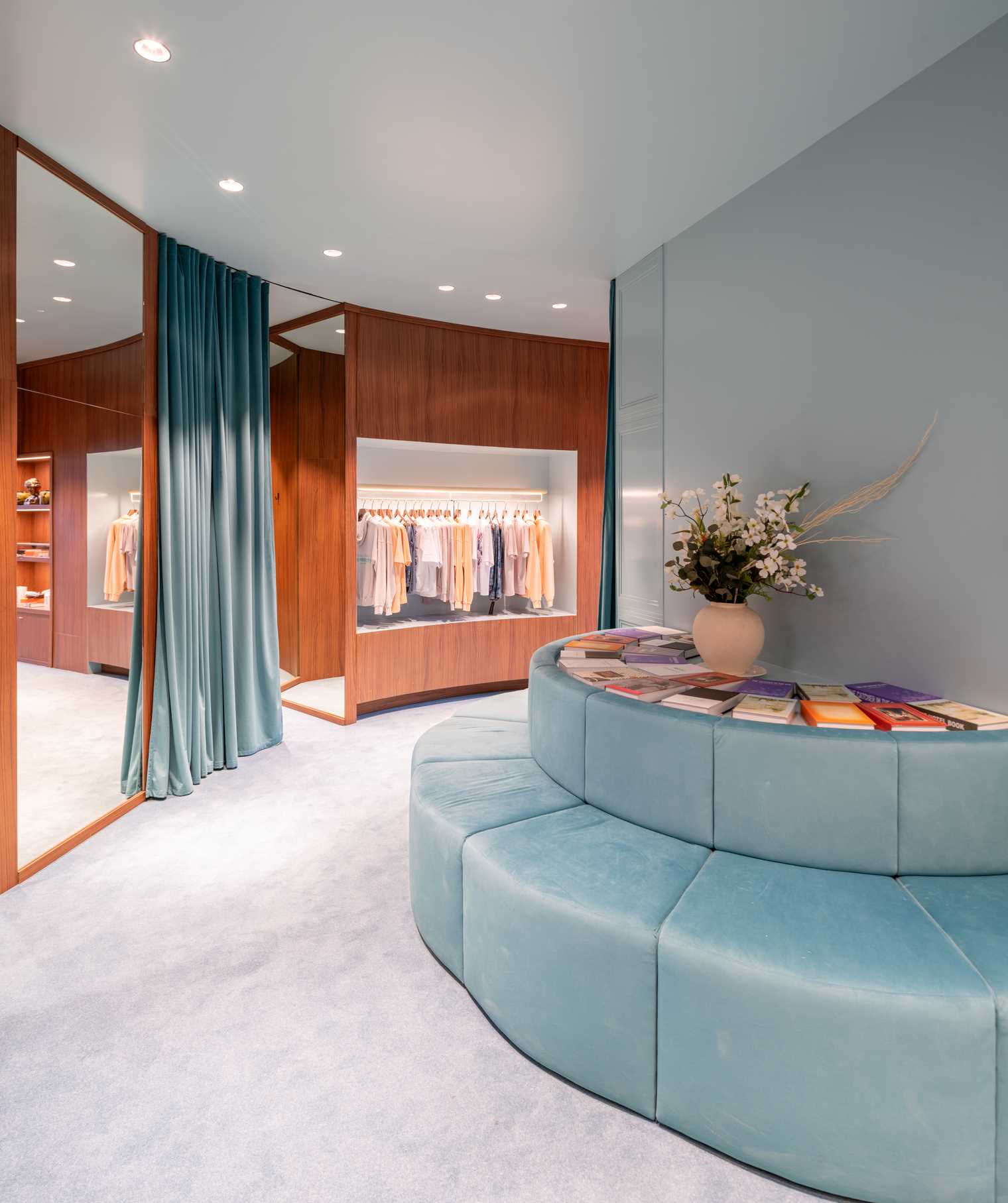 A modern streetwear retail store with 19-foot-high wooden bookshelves, a DJ booth, and a fitting room with baby blue accents.