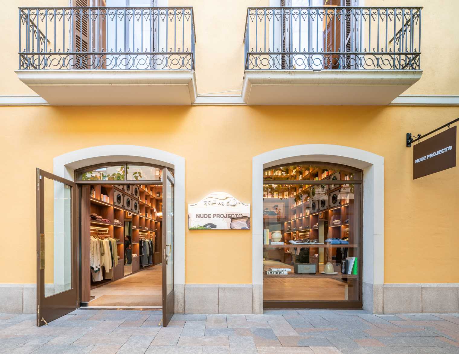 A modern streetwear retail store with 19-foot-high wooden bookshelves, a DJ booth, and a fitting room with baby blue accents.