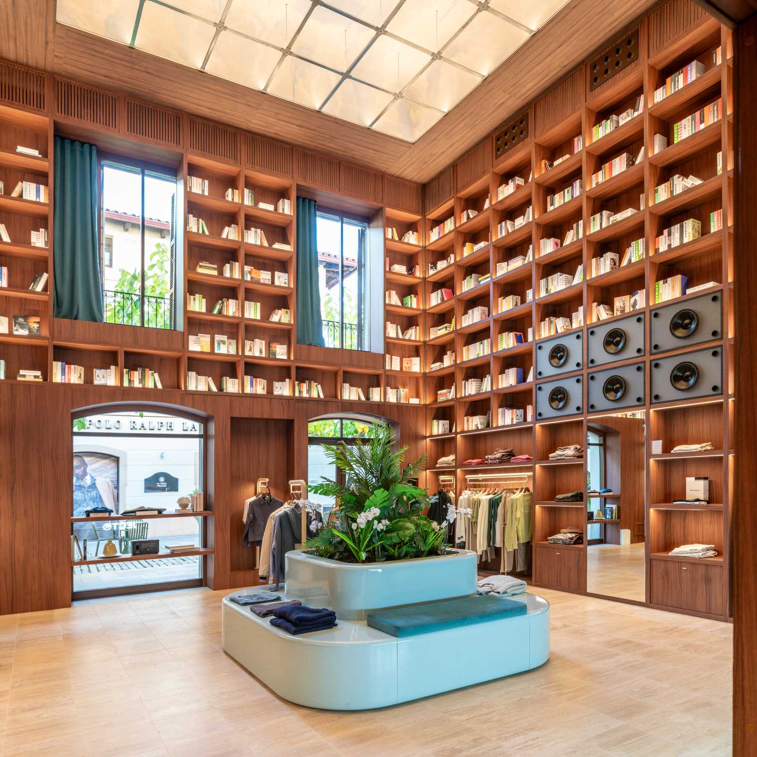 A modern streetwear retail store with 19-foot-high wooden bookshelves, a DJ booth, and a fitting room with baby blue accents.