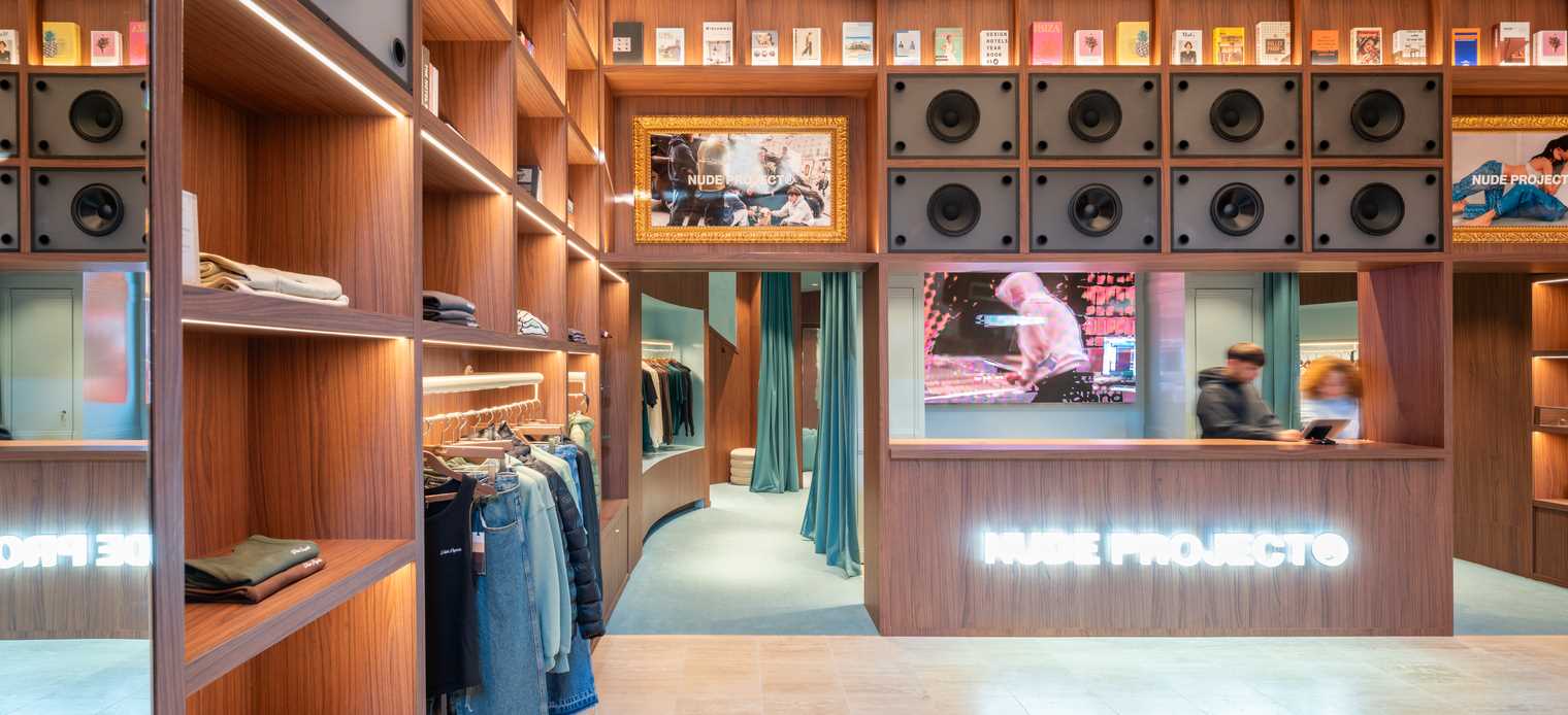 A modern streetwear retail store with 19-foot-high wooden bookshelves, a DJ booth, and a fitting room with baby blue accents.