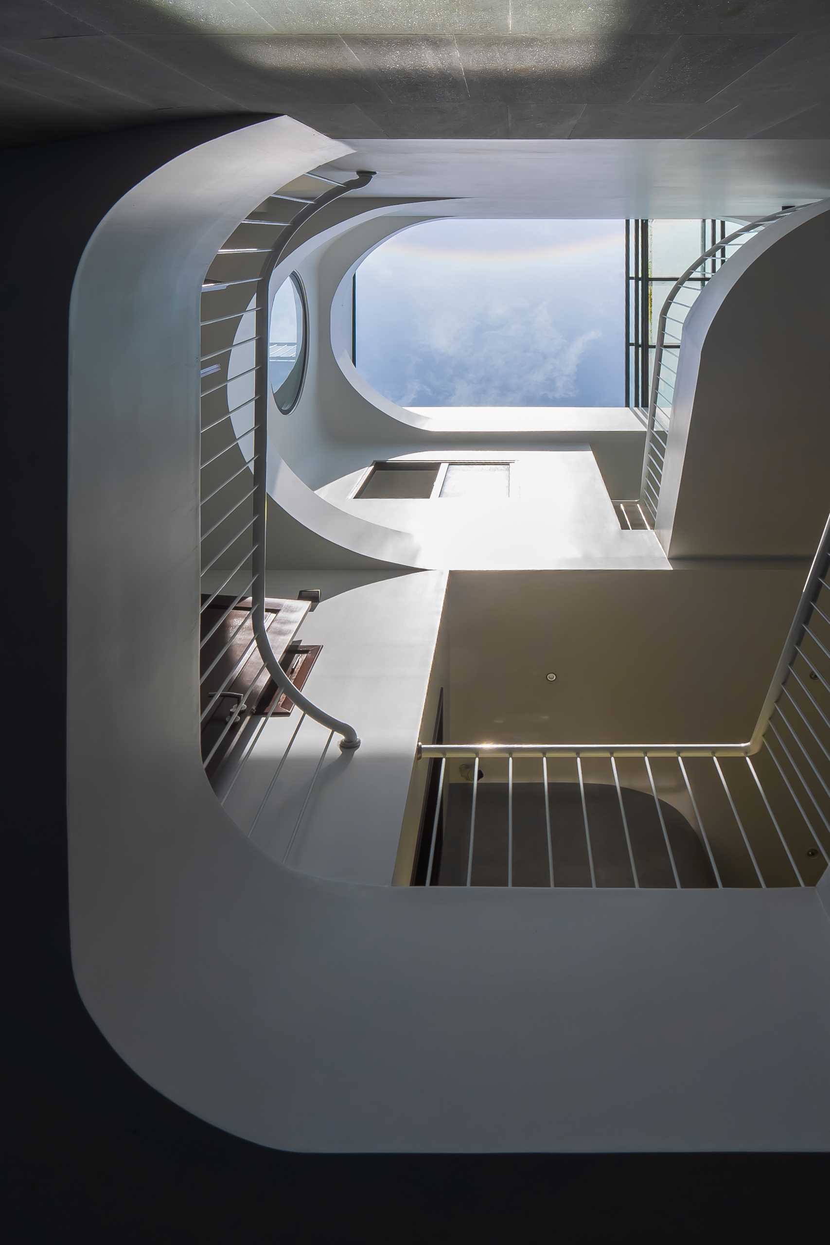 The roof's capsule-shaped openings, inspired by the Dynamic Island feature of the iPhone, are a delicate detail reflecting the profession of the homeowner – the owner of an iPhone dealership.