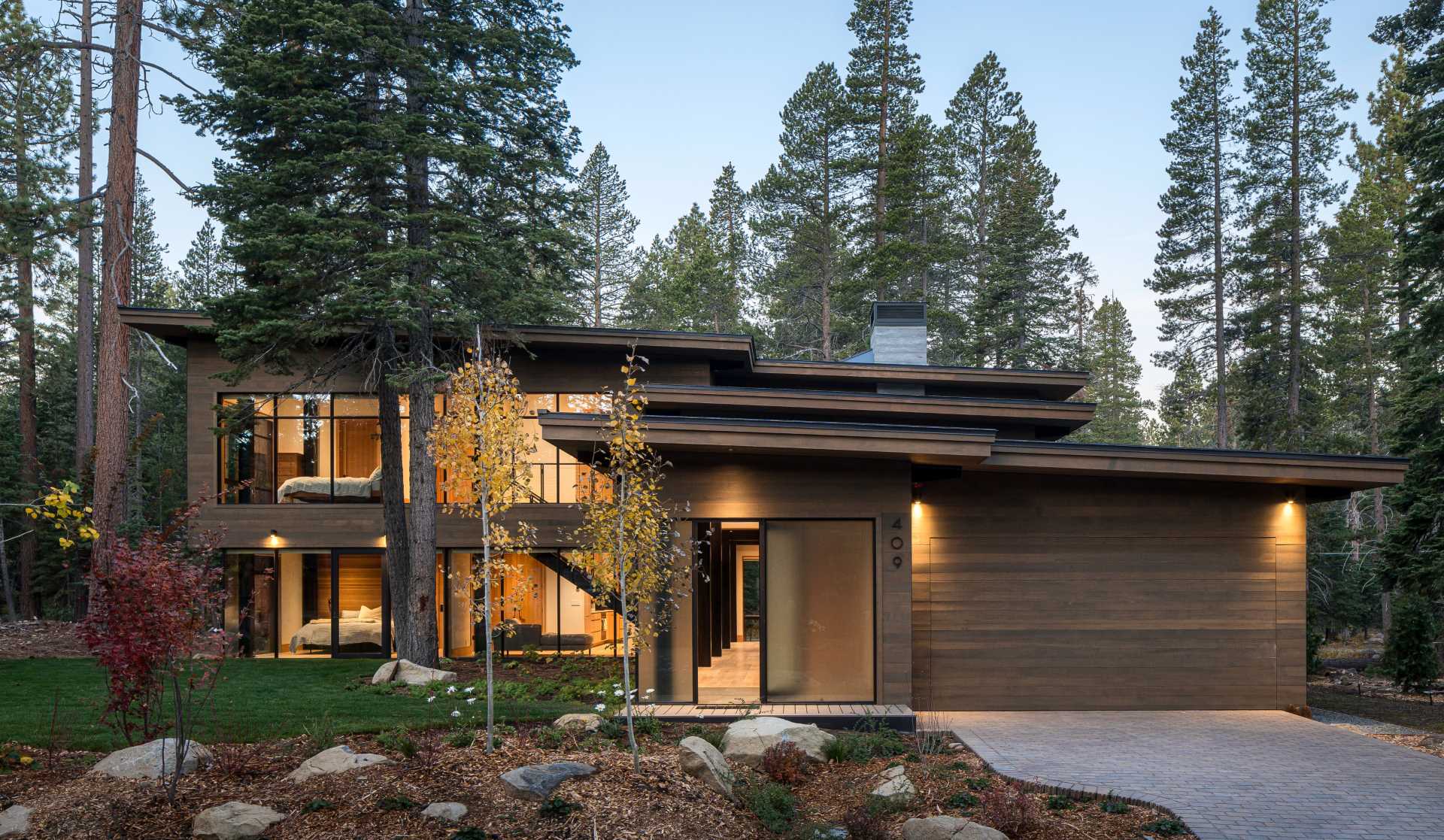 A modern home has an intentionally muted yet refined palette of natural materials including cedar, oak, fir, and steel, allowing the house to harmoniously blend with the surroundings.