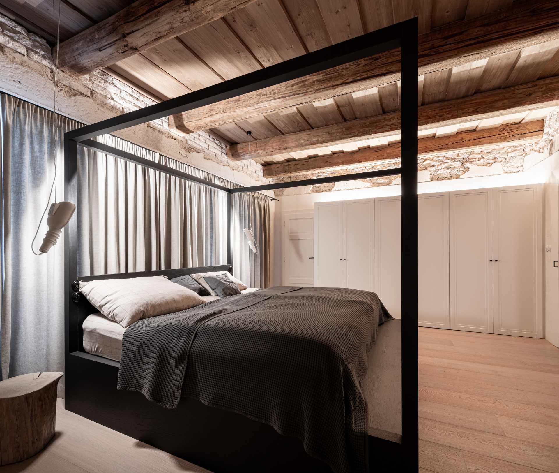 In this bedroom, the designers illuminated wood ceilings indirectly, creating a very pleasant lighting effect in the bedrooms. They also left the plaster "untightened" with exposed brickwork under the ceilings.