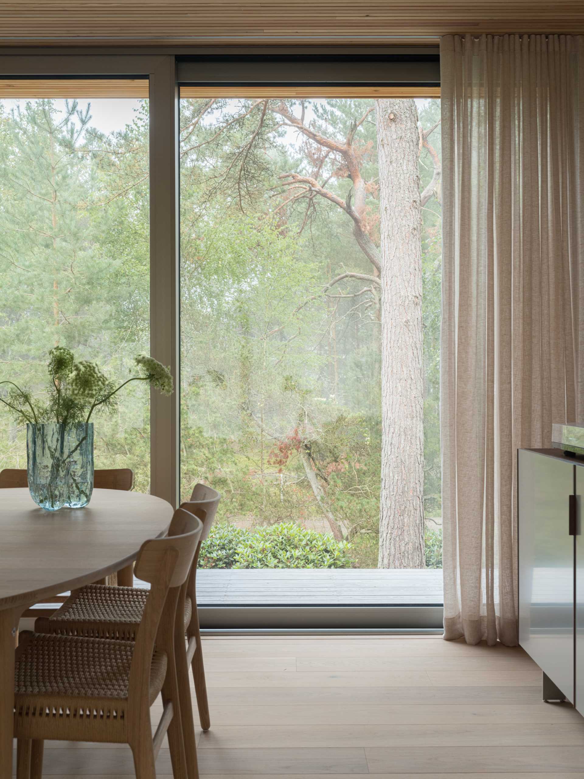 The interior ceiling and its overhanging sections boast a unified, slender-profile larch surface, which has a calming and sound-absorbing effect throughout the entirety of the house.