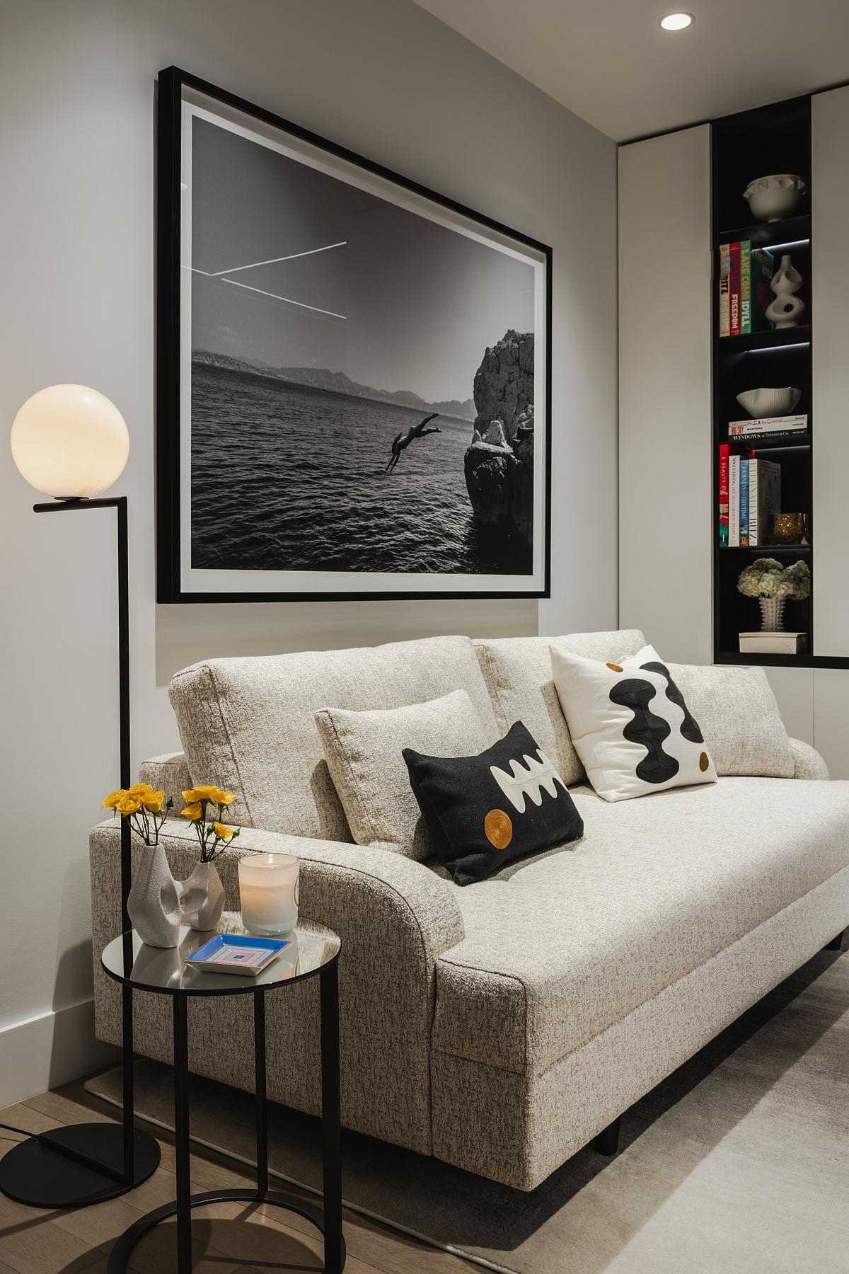 The interior design of a home office. with a couch, built-in desk, textured black leather panels, a mirrored wall, and plenty of storage cabinets.