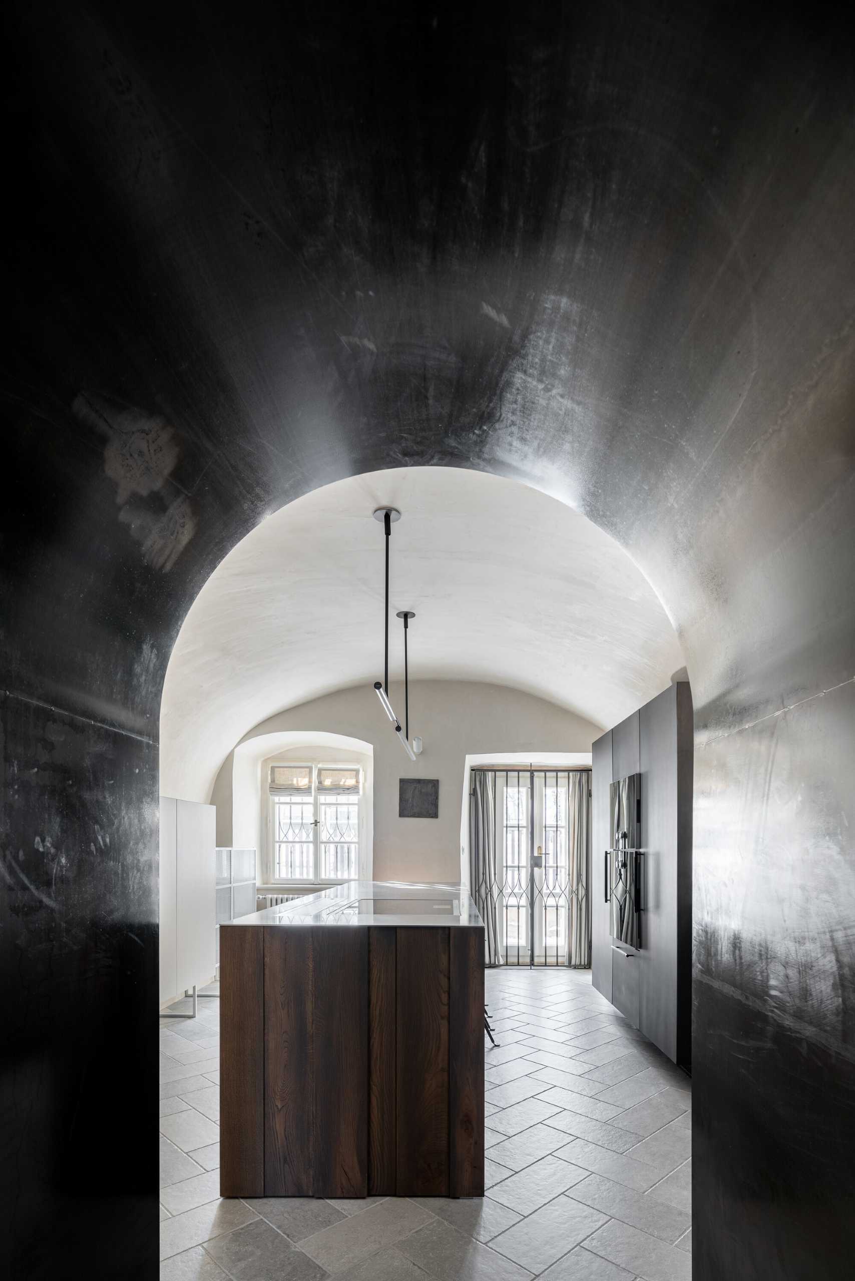 This modern kitchen space with vaults, gave rise to an atypical kitchen unit that respects the arches of the vaults and at the same time has everything you need. The furniture, like all built-in furniture in the house, is completely ventilated. The central island is made of solid wood with a stainless steel worktop, and the other parts of the cabinets have steel doors.