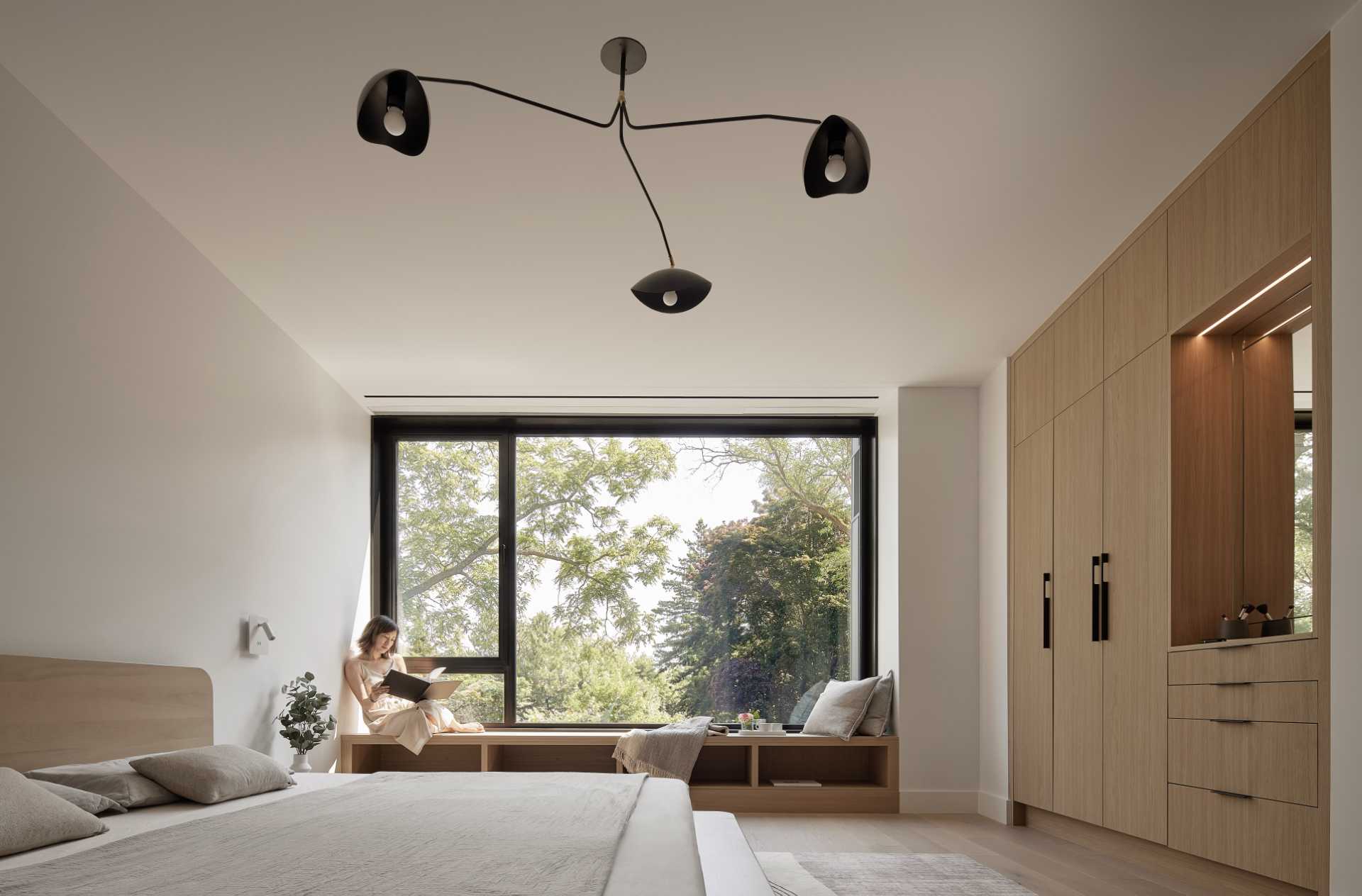 In this primary bedroom, furnishings have been kept minimal and include custom closets and a window bench.