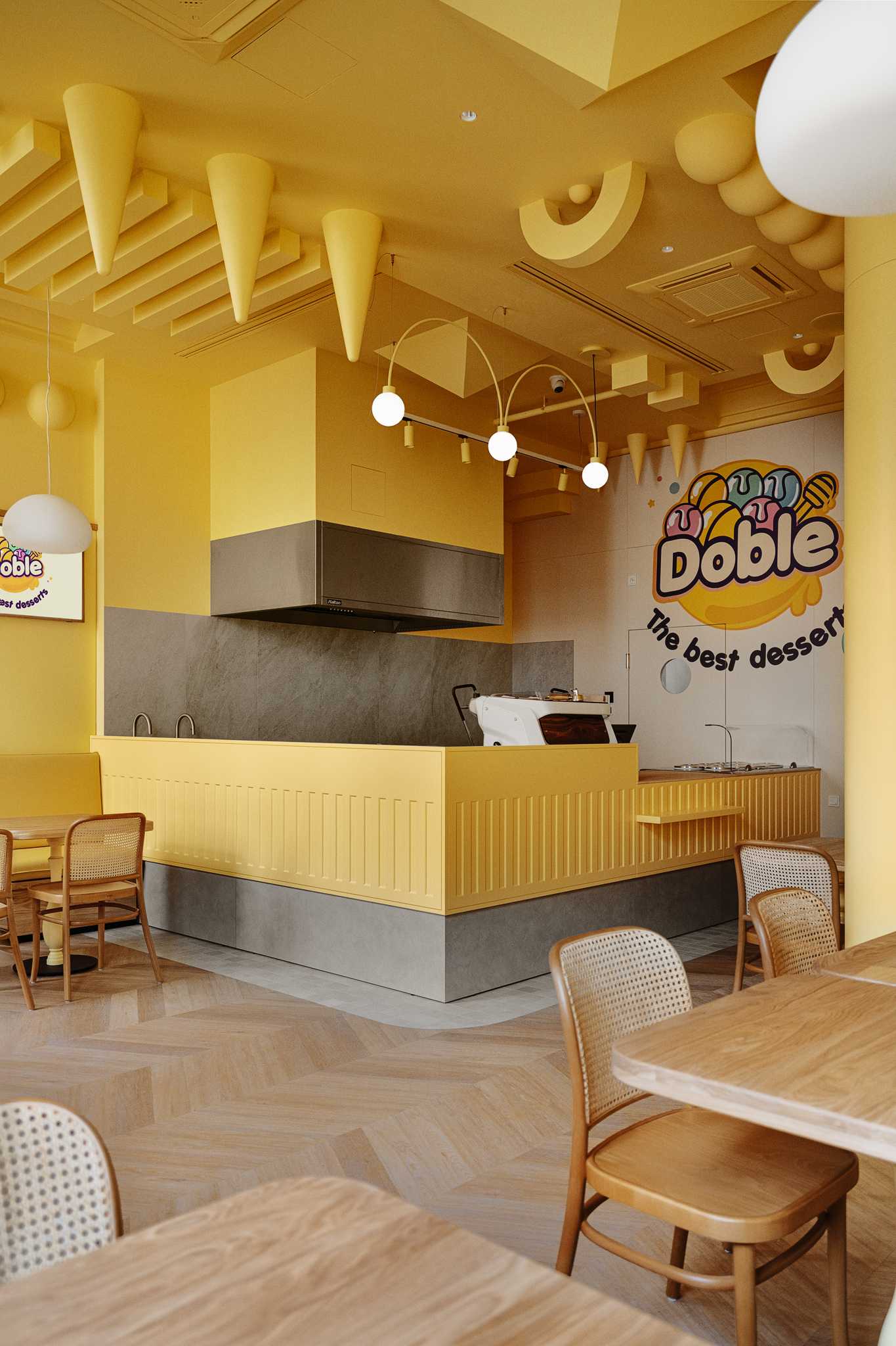 A modern dessert cafe with a bright yellow interior and sculptural ceiling.