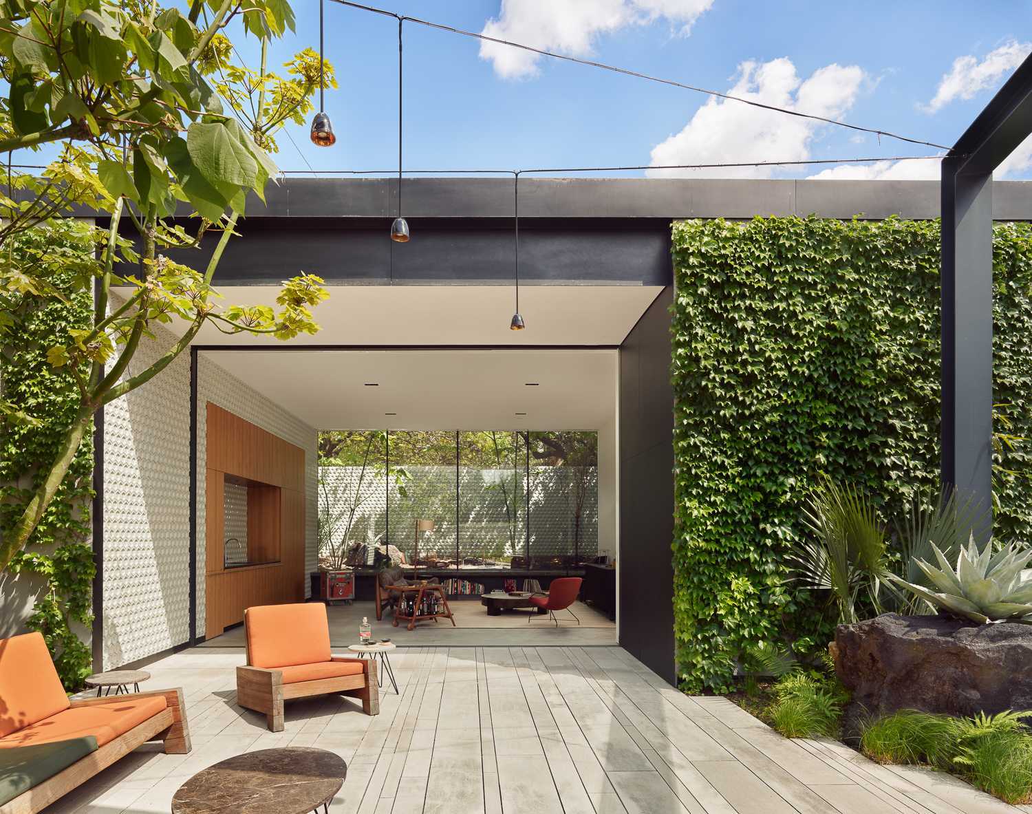 A modern home has a separate, single-story, ivy-covered structure houses the gallery and gallery office, as well as a pool cabana and guest suite.