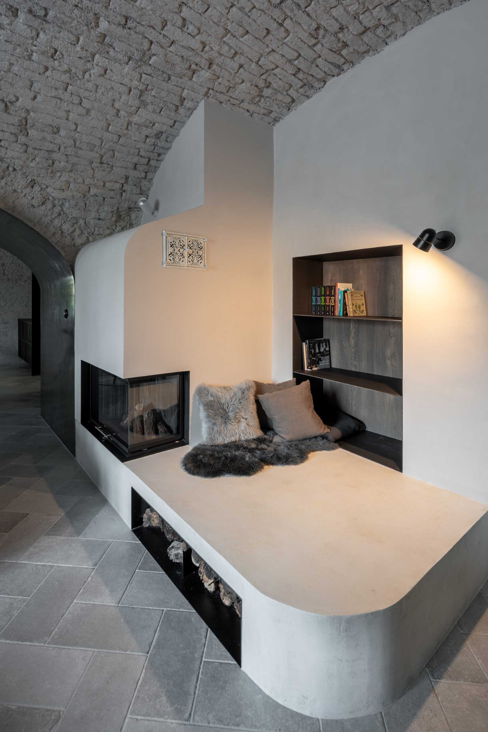 This modern living room in a renovated medieval guard house includes a fireplace with a seating area and built-in bookshelves.