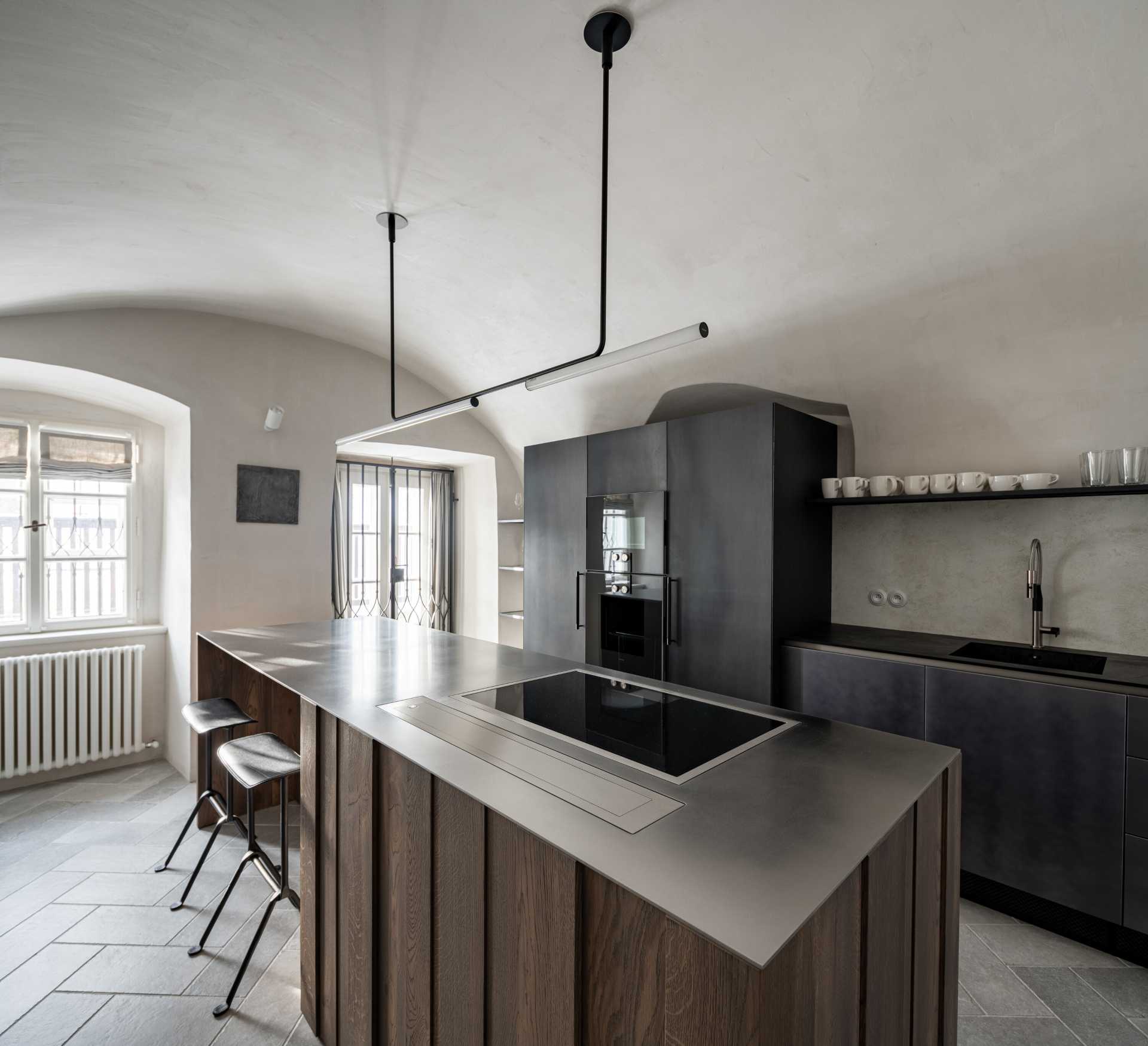 This modern kitchen space with vaults, gave rise to an atypical kitchen unit that respects the arches of the vaults and at the same time has everything you need. The furniture, like all built-in furniture in the house, is completely ventilated. The central island is made of solid wood with a stainless steel worktop, and the other parts of the cabinets have steel doors.