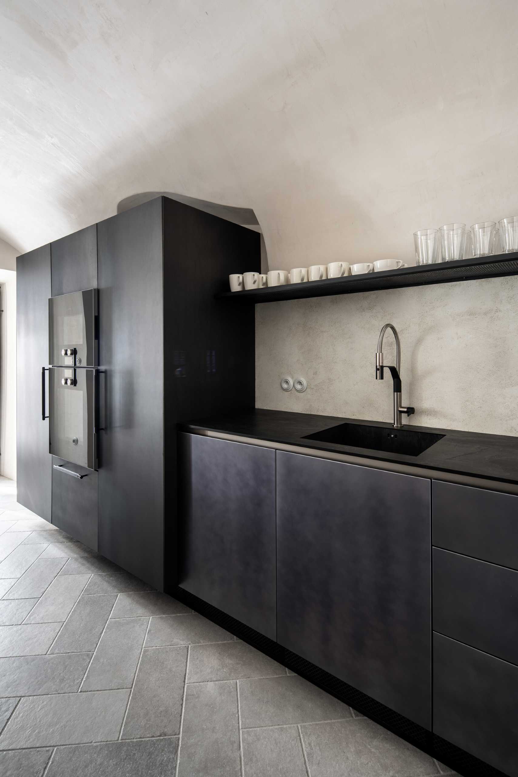 This modern kitchen space with vaults, gave rise to an atypical kitchen unit that respects the arches of the vaults and at the same time has everything you need. The furniture, like all built-in furniture in the house, is completely ventilated. The central island is made of solid wood with a stainless steel worktop, and the other parts of the cabinets have steel doors.