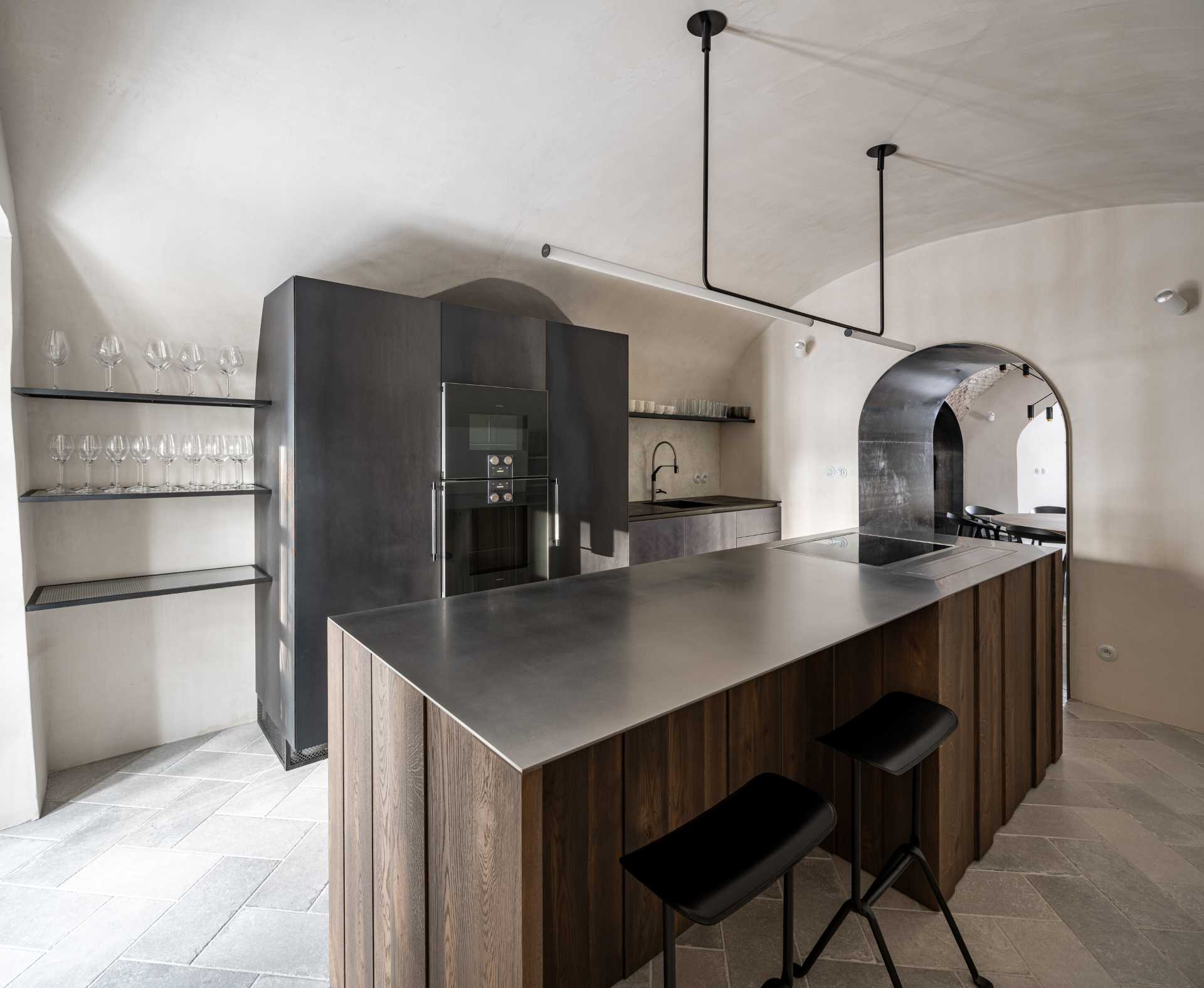 This modern kitchen space with vaults, gave rise to an atypical kitchen unit that respects the arches of the vaults and at the same time has everything you need. The furniture, like all built-in furniture in the house, is completely ventilated. The central island is made of solid wood with a stainless steel worktop, and the other parts of the cabinets have steel doors.