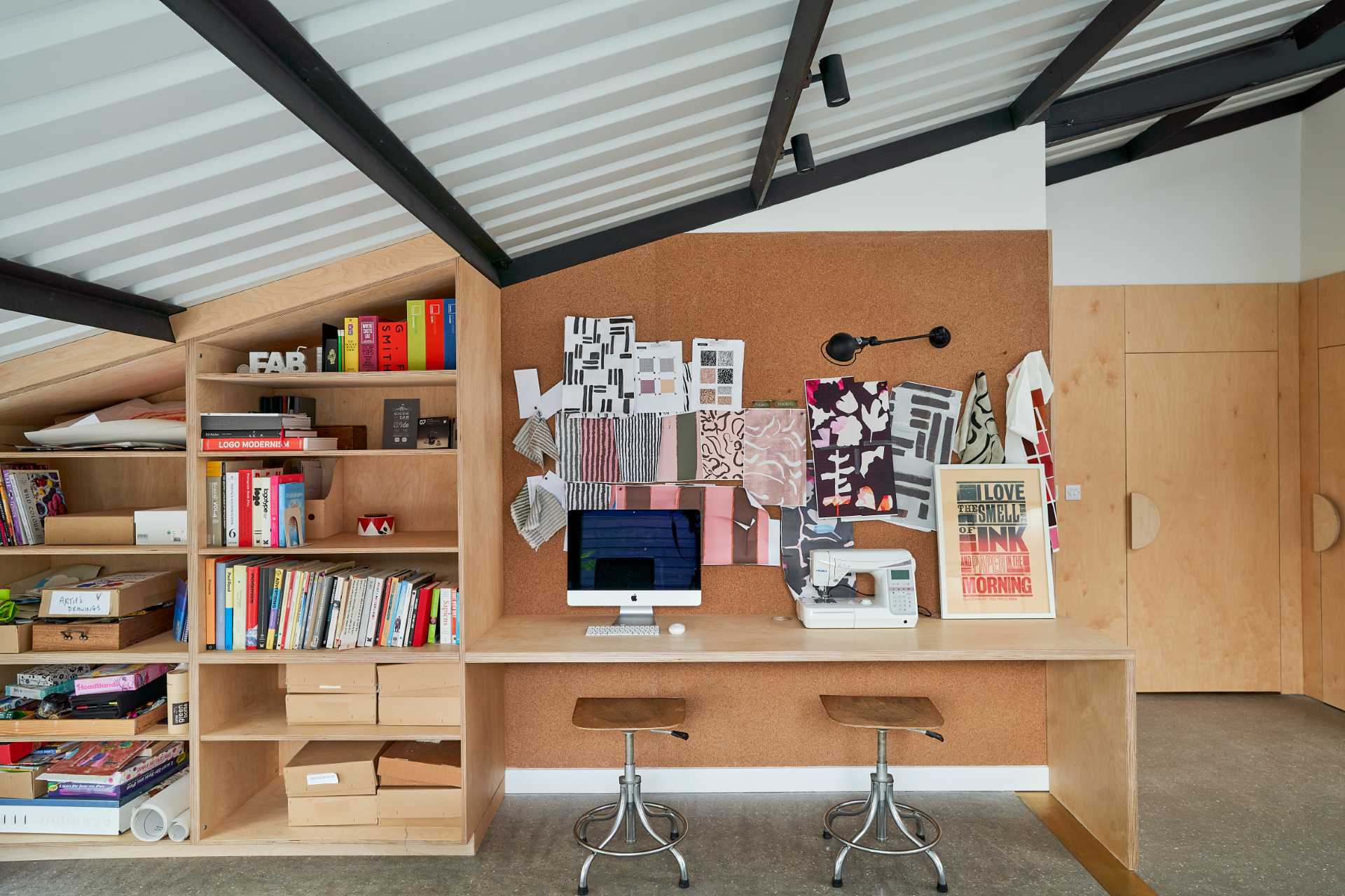 In this home's workroom, there are cork walls, as well as a ply pegboard wall, and different desk areas.