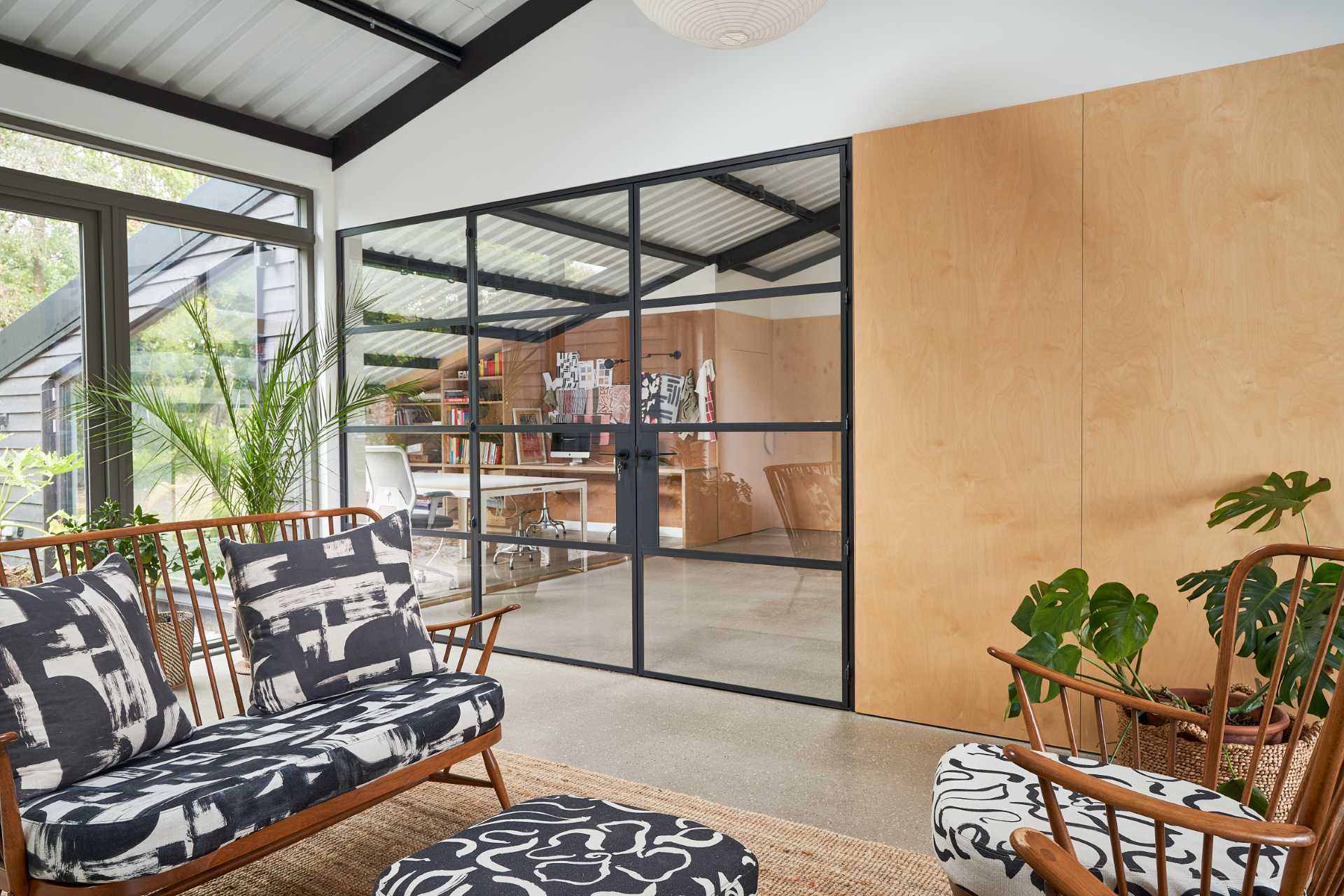 In this home's workroom, there are cork walls, as well as a ply pegboard wall, and different desk areas.