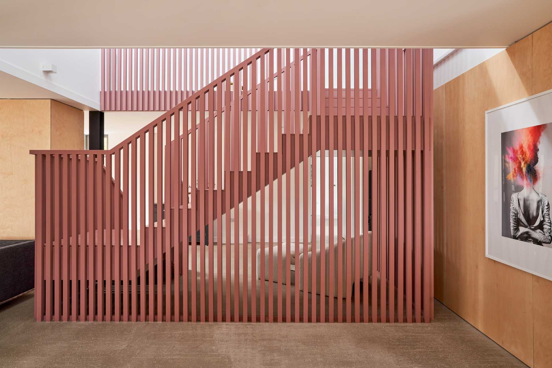 Suffolk Pink inspired stairs add an eye-catching colorful design element to the interior.