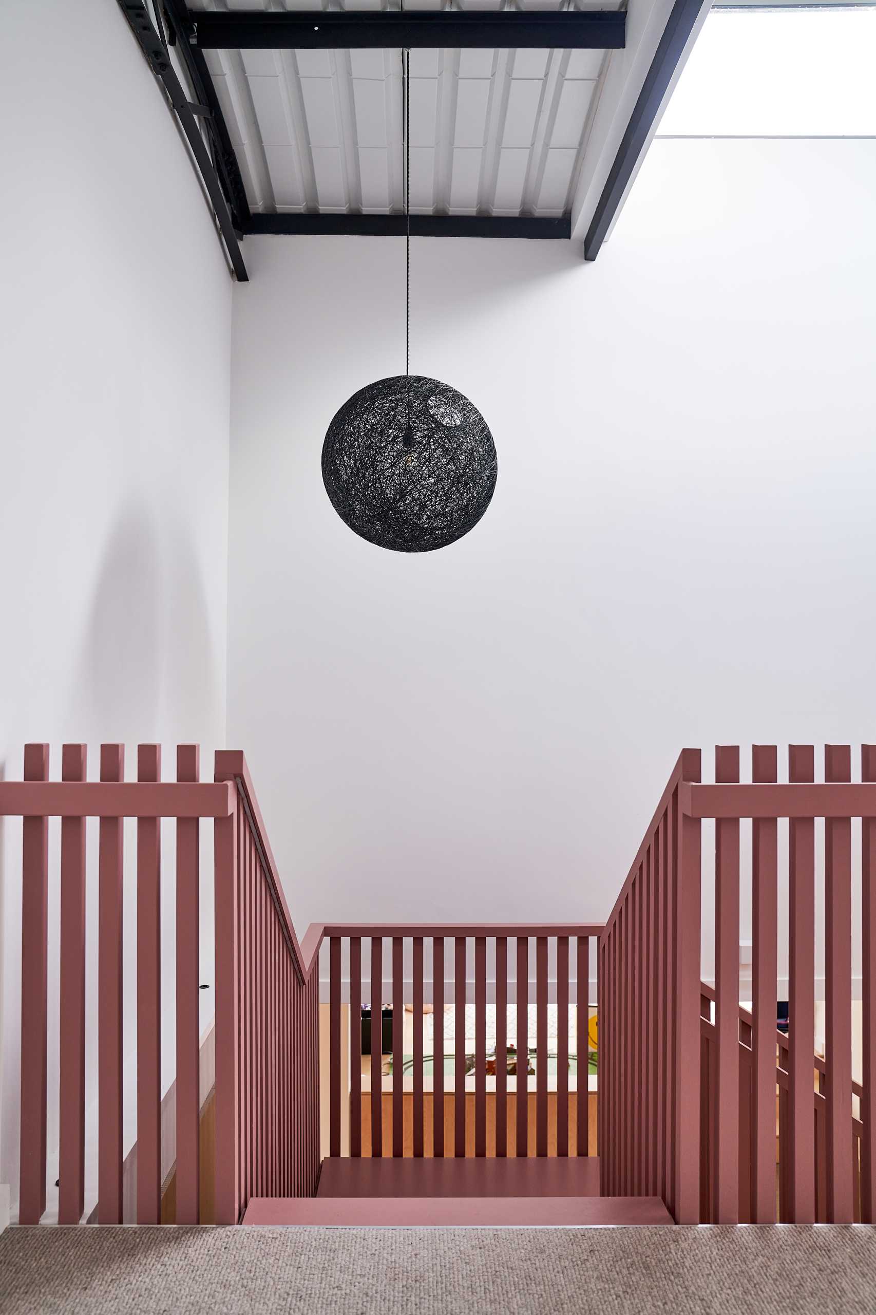 Suffolk Pink inspired stairs add an eye-catching colorful design element to the interior.