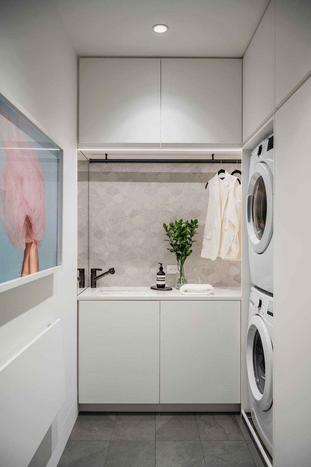 A modern laundry room with stretched-hex porcelain tile, plenty of storage, and a fold-out table.