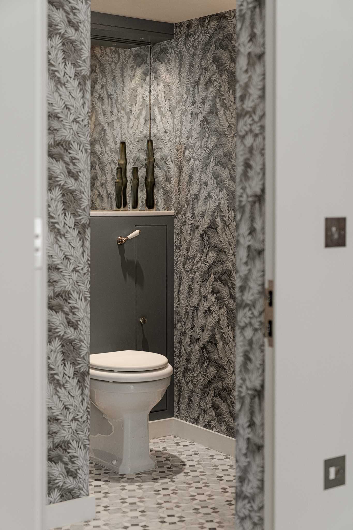 A small guest bathroom with botanical wallpaper.