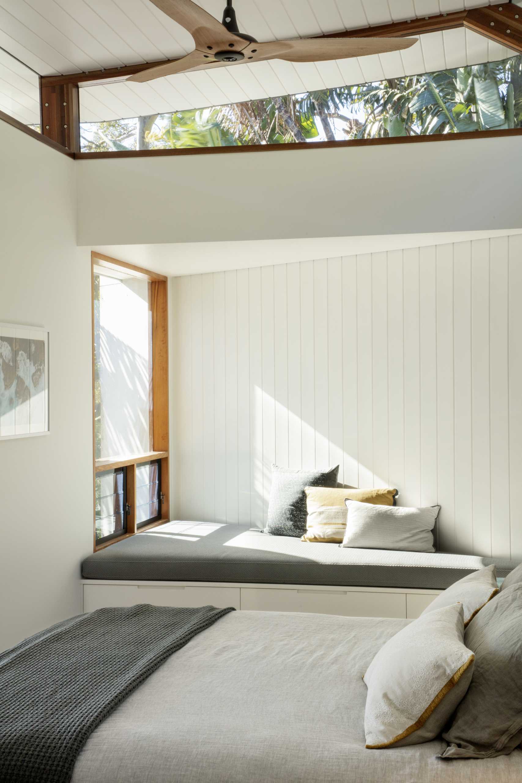 A modern bedroom with a window seat that makes the most of the triangular area.