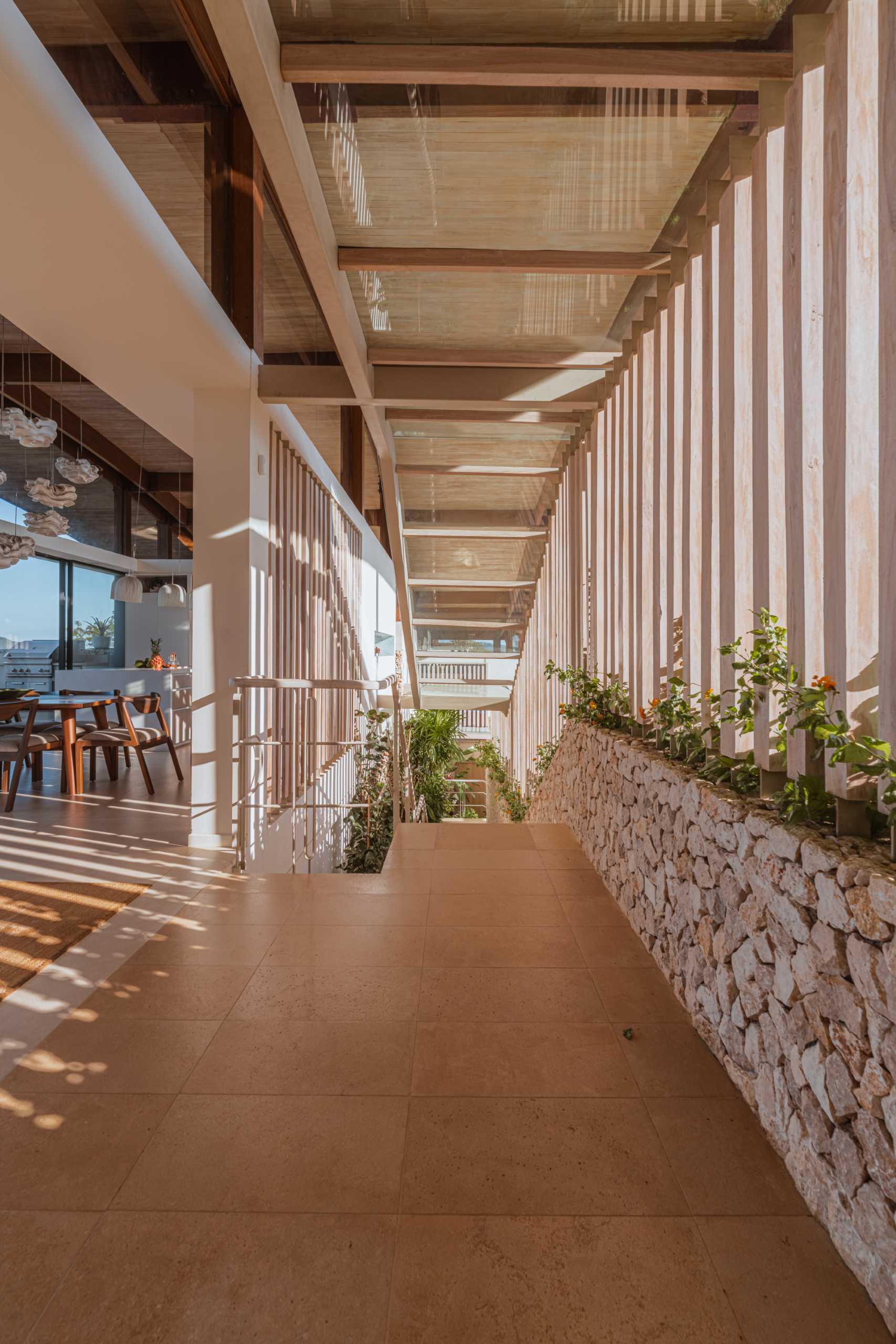 A modern home has a staircase that leads from the entryway up to the open plan social areas, like the living room, dining area, and kitchen.