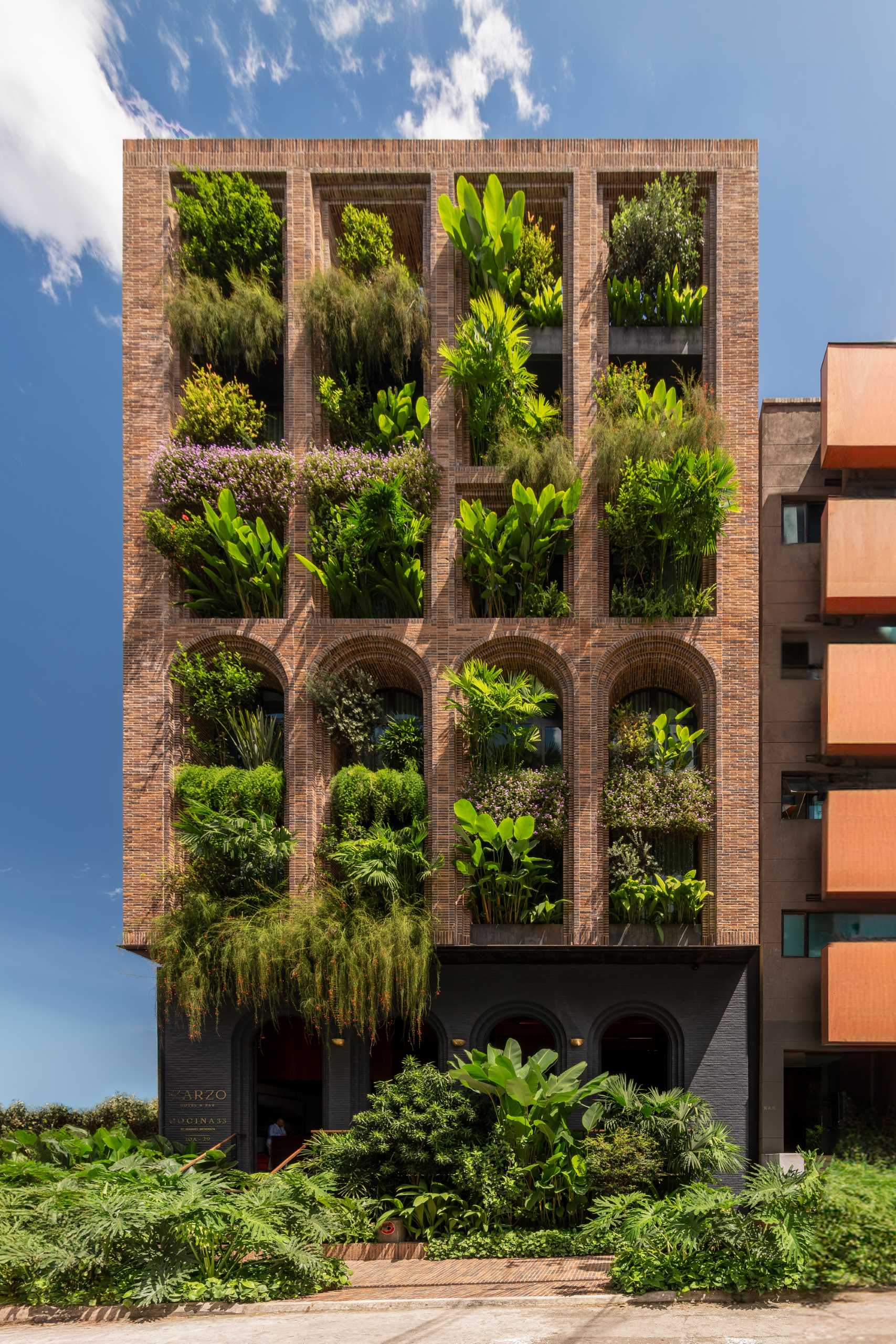 A modern hotel with archways and porticos that houses more than 100 tropical species with an efficient irrigation system.