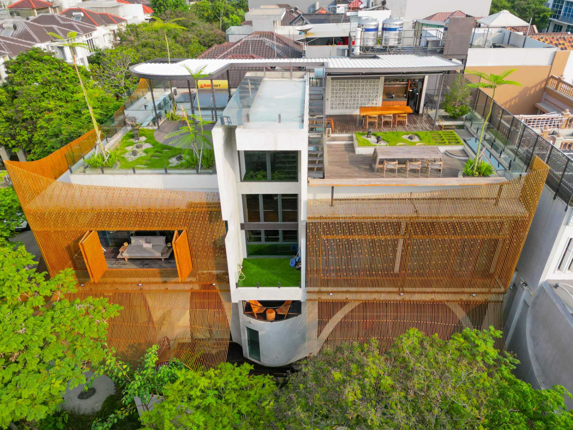 A modern home with a rooftop garden, outdoor kitchen, and multiple dining areas.