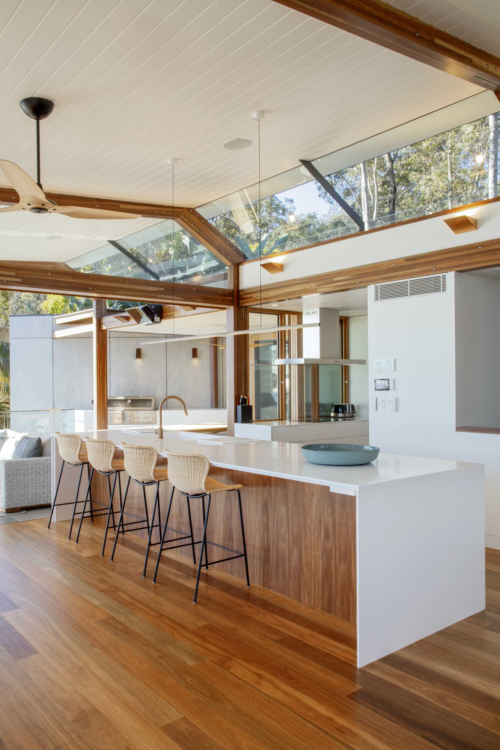 The kitchen has a long island, with the white countertops complementing the white walls and ceiling.