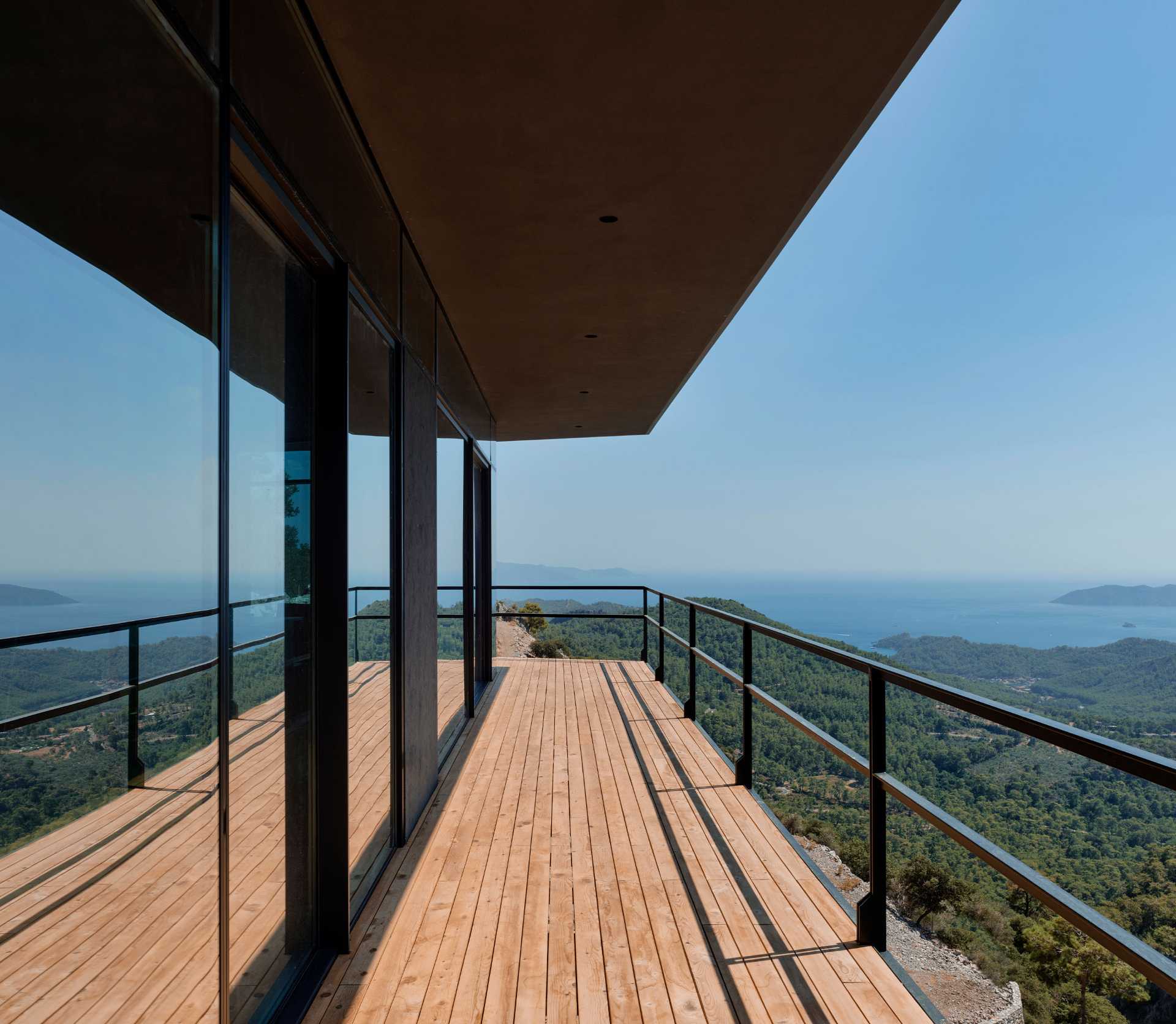 A small one-bedroom cabin with an open plan interior, is made from steel construction and a glass facade.