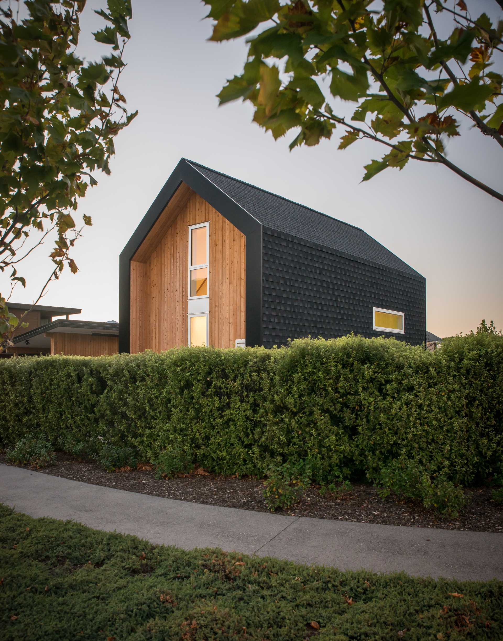 A small one bedroom home with an exterior of asphalt shingles and larch weatherboards.